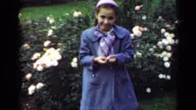 New York (1947): A Young Girl In A Coat And Twirly Beanie Hat Bends Over And