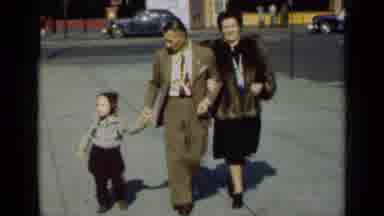 New York (1947): Man Wearing Tan Suit Walks With Girl Wearing Grey Sweater