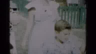 New York (1950): Woman Wearing White Dress With Sunglasses Stands In Front Of