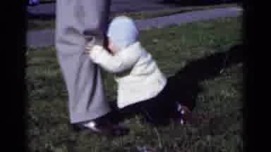 New York (1950): Baby Clinging Onto Parents Leg For Support To Stand Up