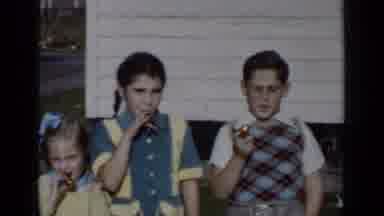 New York (1950): Three Kids Blowing Kazoos Near White Building On A Sunny Day