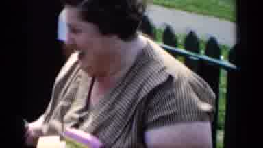 New York (1951): Woman Wearing White Shirt Laughs At Cameraman Near Green Fence