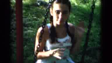 New York (1951): A Young Girl With Braids Waves While Swinging On A Swing With Two