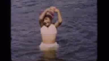New York (1951): Young Girl Wearing A White Bathing Suit Stands In A Large Body Of