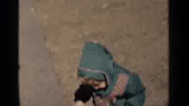 New York (1951): Toddler Wearing Green Coat Pushes Purple Toy Baby Carriage On A