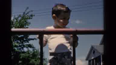 New York (1951): Young Smiling Boy Playing Outside And Climbing Down A Ladder Into