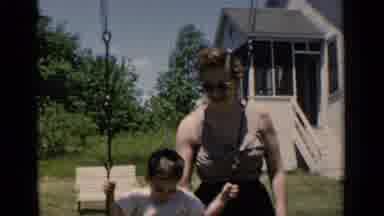 New York (1951): A Mother Plays With His Son Happily At Their Home Swing