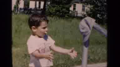 New York (1951): Boy Wearing White Shirt Removes Grey Hat From Metal Bar On A