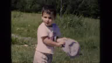 New York (1951): A Young Boy Is In A Field Playing With A Hat