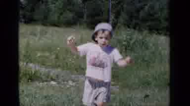 New York (1951): Boy Wearing Blue Hat Points Down At Ground On A Bright Sunny Day