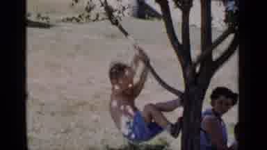 New York (1951): A Small Child Trying To Climb A Tree While A Woman Sits On The