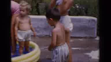 New York (1951): Boy Wearing Grey Shorts Steps Into Yellow Kiddie Pool On A Clear