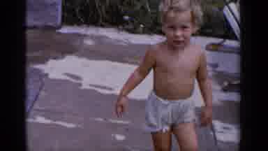 New York (1951): Toddler With Curly Blonde Hair Wanders Around In The Yard In