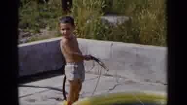 New York (1951): Boy Playing With Water Gun Outside Trying To Fill His Plastic