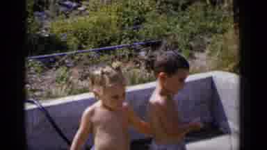 New York (1951): A Shirtless Little Boy And Girl Holding A Water Hose Together