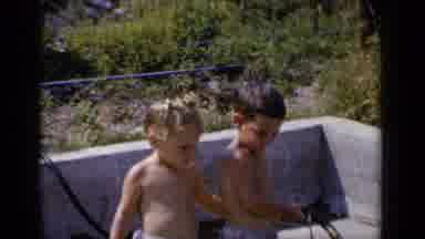 New York (1951): A Young Male Toddler Holds A Hose And Then Turns To Kiss A Female