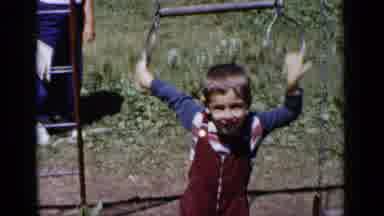 New York (1951): Kid Playing On Playground Swinging Around As He Smiles