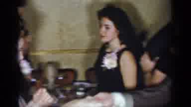 New York (1954): Woman Wearing Blue Dress Dances With Man Wearing Brown Suit