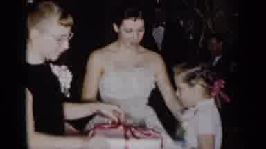New York (1954): Woman Wearing Blue Dress Removes White Ice Skates From Red Gift
