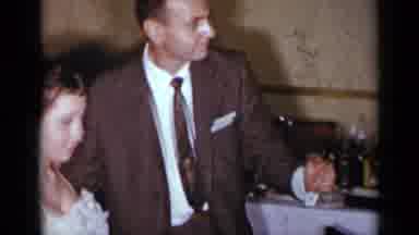 New York (1954): Woman Wearing White Dress Dances With Man Wearing Brown Suit