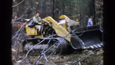 Birmingham Alabama (1957): Man Drives A Yellow Front End Loader Through A Path In