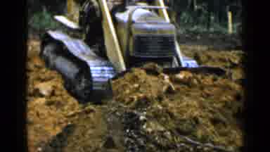 Birmingham Alabama (1957): Man Using A Yellow High Lift Bucket To Push Large