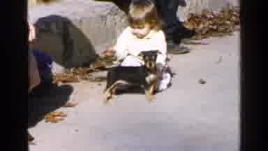 Birmingham Alabama (1957): Girl Toddler Pets And Hugs Black Puppy And Returns To