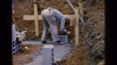 Birmingham Alabama (1957): Worker Laying Cinder Blocks On Concrete Surrounded By