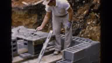 Birmingham Alabama (1957): Man In White Shirt And Khaki Pants Putting Cement On