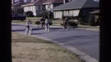 Birmingham Alabama (1957): Four Children Riding Bicycles On A Paved Street In A