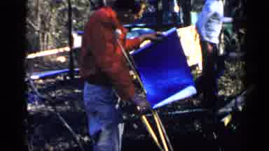 Birmingham Alabama (1957): A Man On Crutches Standing Outside Looking Over Some