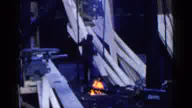 Birmingham Alabama (1957): Person Stacking Lumber Near Small Fire On A Clear Day