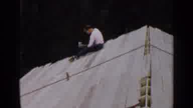 Birmingham Alabama (1957): Man Hammers White Tarp As He Slides Along Wooden
