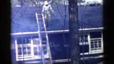 Birmingham Alabama (1957): Man Working On Roof Descend Ladder To Come Warm Up By