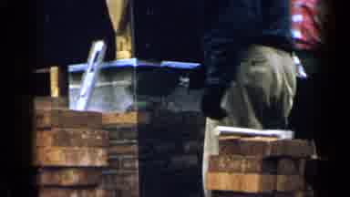 Birmingham Alabama (1957): Person Wearing Tan Pants Applies Brick Mortar On A