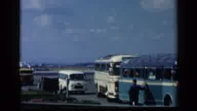 Vatican Italy (1960): Man Wearing Blue Shirt Stands Beside Blue Bus On A Sunny Day
