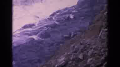 California USA (1963): Waves Crash On Shoreline Rocks As Sea Lions Move Around On