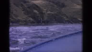 Idaho USA (1963): Boat Sailing Through The Sea With Rough Tide On A Clear Sky Day