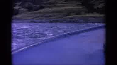 Washington USA (1963): A Boat Glides Over Smooth Waters Toward A Green Hilly