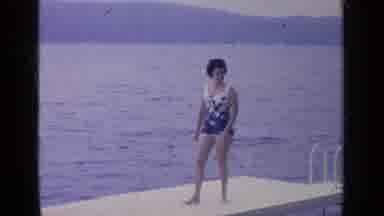 Greenwood Lake New York (1964): Woman Wearing Blue Swimwear Walks On White