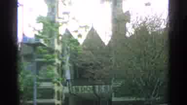 Flushing Meadows New York (1964): A Tall Building Covered By Trees And Carts
