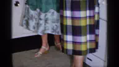 Long Island New York (1965): Woman Wearing Green Dress Hands Object To Woman