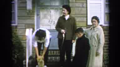 Long Island New York-1965: Lady Puts A Leash On A Cat As Family Watches