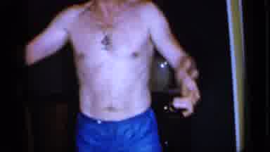 Mineola New York (1966): Man Wearing Blue Shorts Stands On Brown Carpet Next To