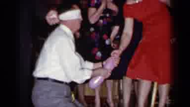 Mineola New York (1966): Blindfolded Man Wearing White Shirt Removes Garter From