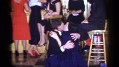 Mineola New York (1966): Couple Kiss At Gathering While People Talk In The