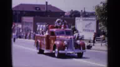 Mineola New York (1966): Small Fire Truck With Flowers Behind It Riding Down