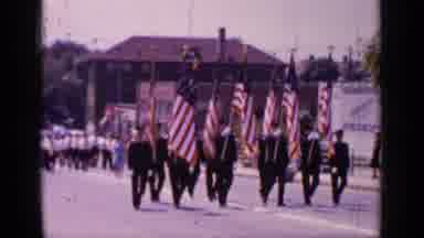 Mineola New York (1966): Color Guard Carrying Seven American Flags Marches Down