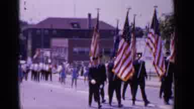 Mineola New York (1966): People Holding Flags Marching Down A Road As Crowd