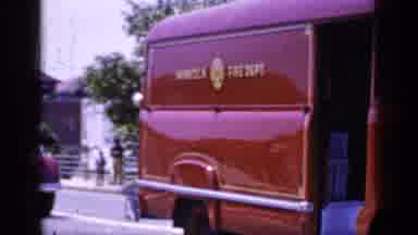 Mineola New York (1966): There Are Two Red Old Style Cars Driving Pass A Few